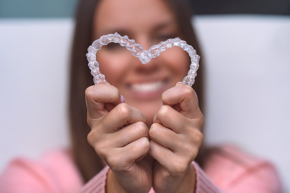 Woman with perfect smile after invisible invisalign aligners treatment. High quality photo